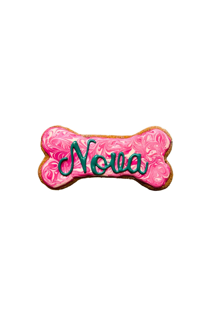 One swirl name bone dog treat. The name on the bone is Nova. The colors are pink and white.